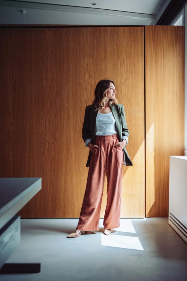 Confident Businesswoman Posing in Modern Office Wearing Trendy Outfit
